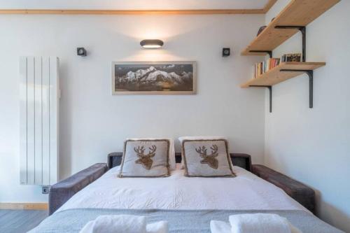 a bedroom with a bed with two pillows on it at Prarion - Modern apartment Next to Ski lift - By Cozee Rentals in Les Houches