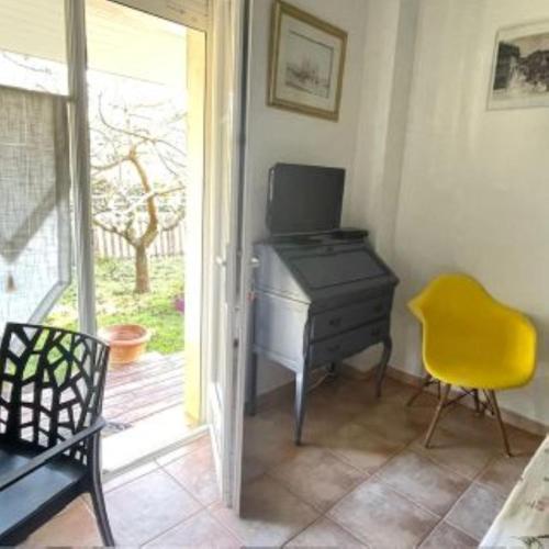 un bureau avec un bureau et une chaise jaune dans l'établissement Chambres d'Hôtes d'Aliénor, à Soulac-sur-Mer