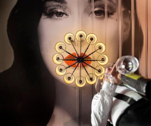 a woman holding a wine glass in front of a wall at Le Theatre in Maastricht