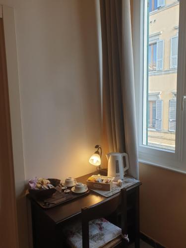a table with a lamp on it next to a window at Affittacamere Euro in Ancona