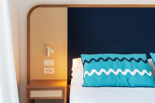 a bed with a blue headboard and a blue pillow at Grand Hotel Flora in Sorrento