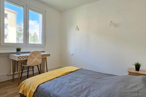 une chambre avec un lit, un bureau et une fenêtre dans l'établissement C'est chez Maurice! 4 ch WIFI balcon parking free, à Saint-Étienne