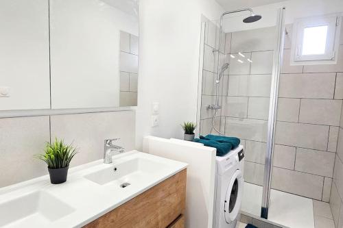 une salle de bain blanche avec une machine à laver et un lavabo dans l'établissement C'est chez Maurice! 4 ch WIFI balcon parking free, à Saint-Étienne