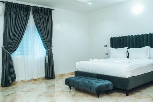 a bedroom with a large bed and a large window at 505 Apartment by Wetland Hotel in Warri
