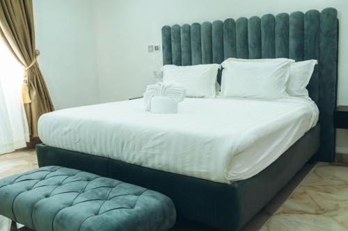 a bedroom with a large bed with a blue headboard at 505 Apartment by Wetland Hotel in Warri