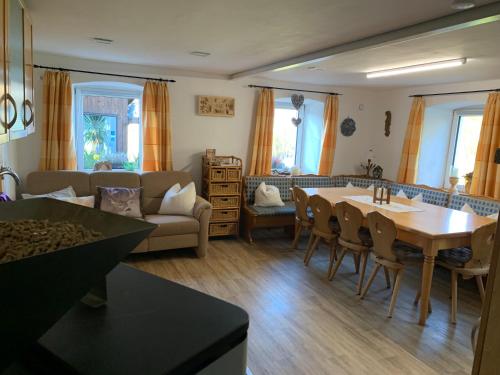 a living room with a table and a couch at Ferienhaus Ramersdorf in Kollnburg