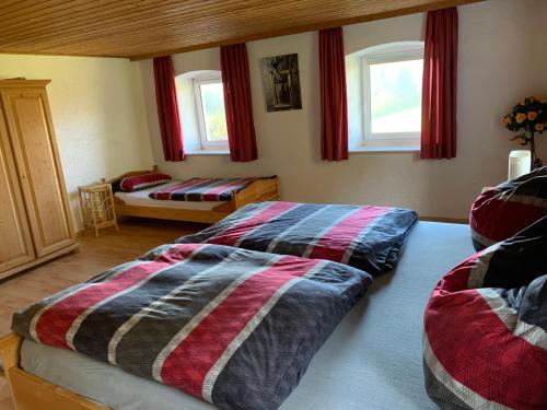 a bedroom with two beds and two windows at Ferienhaus Ramersdorf in Kollnburg