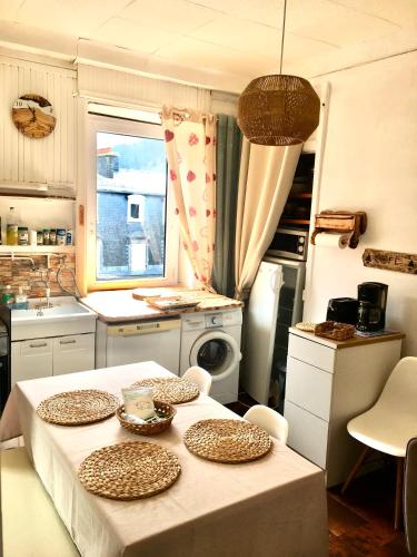 une cuisine avec une table avec des assiettes dessus dans l'établissement Hyper centre dans ancien palace face aux thermes, à Mont-Dore