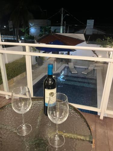 a bottle of wine and two wine glasses on a table at Residence Dunas Exclusive in Natal