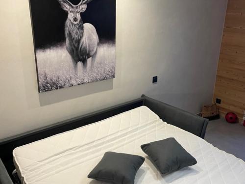 - une chambre avec un lit avec une photo de cerf dans l'établissement Studio cosy 4 pers., proche pistes, piscine chauffée, salle de jeux, centre à 450m - FR-1-467-104, au Grand-Bornand