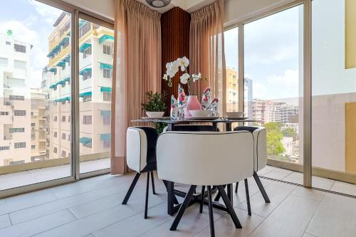 a dining room with a table with white chairs and large windows at Chic Centric 1BR Apt, King Bed in Los Prados