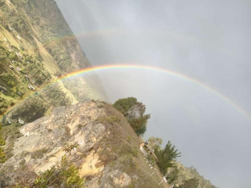 a rainbow in the sky over a mountain at Luna Llena in Suesca