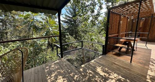 a wooden deck with a bench on it at Omghat Glamping - Domo Sarasvasti in El Peñol