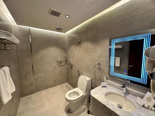 a bathroom with a toilet and a sink at فندق حياة تاون املج 1 in Umm Lajj