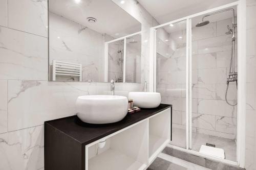 une salle de bain blanche avec un lavabo et une douche dans l'établissement Super appartement 2BR 6P Bastille, à Paris