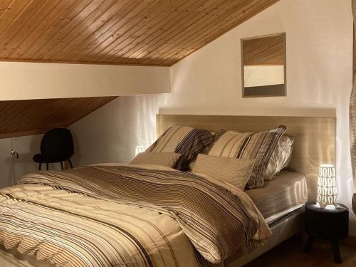 une chambre avec un grand lit avec un plafond en bois dans l'établissement Appartement cosy à Châtel : 5 pers, balcon, parking, WIFI - FR-1-676-32, à Châtel
