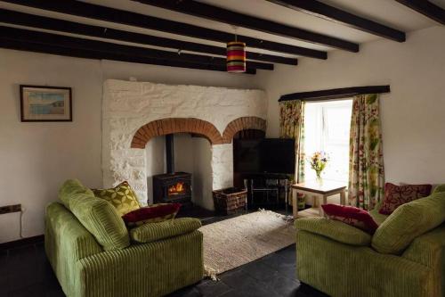 a living room with two chairs and a fireplace at Trefrane Lodge in HAW