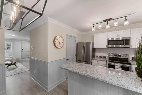a large kitchen with a clock on the wall at Golf Oasis Modern Townhome! in Charlotte