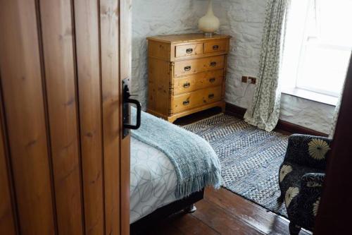 a bedroom with a bed and a dresser and a window at Trefrane Lodge in HAW