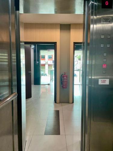 a hallway of a building with two elevators and doors at Crystal Studio Apartment KBCP in Kota Bharu
