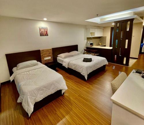 a hotel room with two beds and a kitchen at Crystal Studio Apartment KBCP in Kota Bharu