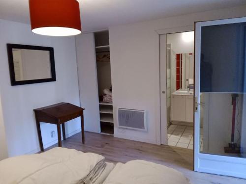 Cette chambre comprend un lit, une table et une télévision. dans l'établissement la campagne aux portes de Toulouse, à Vigoulet-Auzil