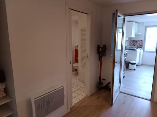 un couloir avec une porte menant à une cuisine et une salle de bains. dans l'établissement la campagne aux portes de Toulouse, à Vigoulet-Auzil