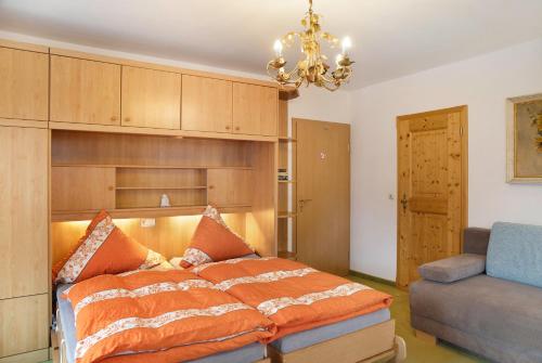 a bedroom with a bed and a couch and a chandelier at Gästehaus Arkadia - Ferienwohnung 3 in Garmisch-Partenkirchen