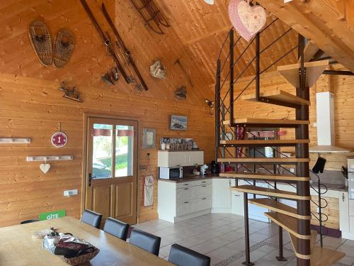 - une cuisine et une salle à manger avec un escalier en colimaçon dans une cabine dans l'établissement chalet l'échappée belle, à Murat-le-Quaire