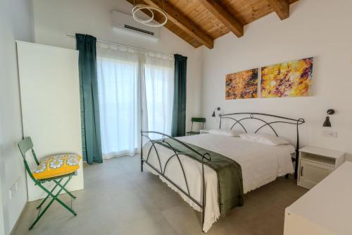 a bedroom with a bed and a chair and windows at Villa Margherita in Francavilla dʼEte