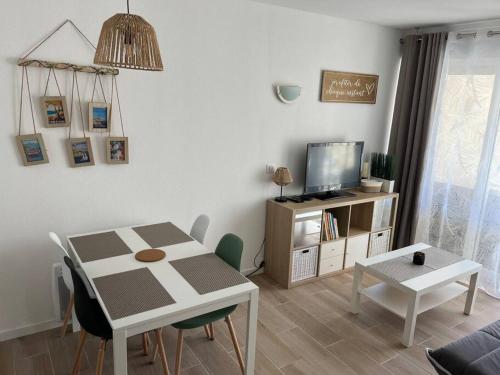 un salon avec une table et une télévision dans l'établissement F2 climatisé, piscine, parking, tout à pied, à Antibes