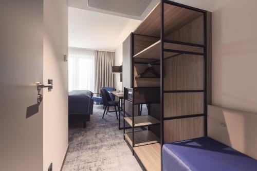 a room with a bed and a room with a closet at Garner Hotel Augsburg Nord by IHG in Augsburg