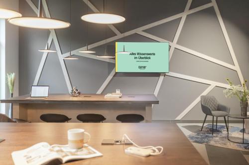 a conference room with a table and a projector screen at Garner Hotel Augsburg Nord by IHG in Augsburg