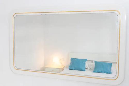 a mirror reflection of a bed with two blue pillows at Apartamento Don Guido Bajo in Barbate