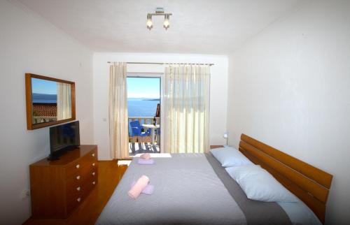 a bedroom with a bed and a television and a window at Apartments Mare in Brela