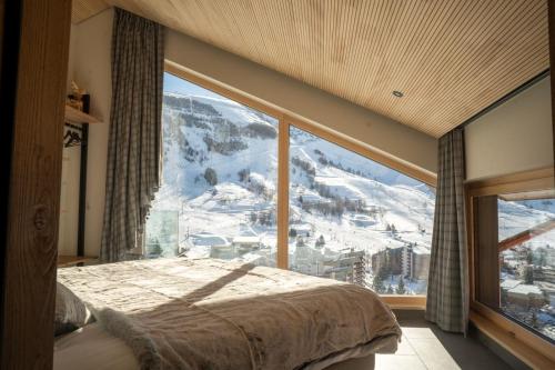 - une chambre avec une grande fenêtre offrant une vue sur la montagne dans l'établissement Chalets Horizon Blanc - Vue exceptionnelle -Sauna extérieur -5 étoiles, à Les Deux Alpes