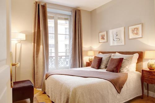 une chambre avec un grand lit et une fenêtre dans l'établissement Blanc Manteau Residence, à Paris