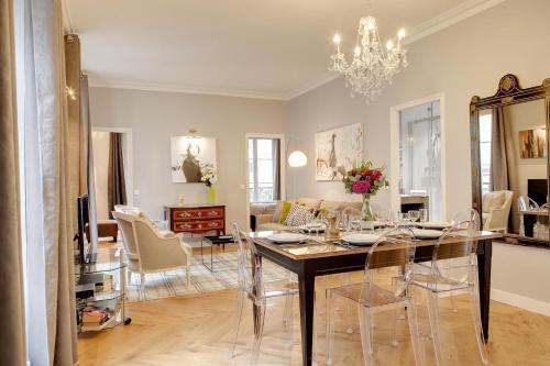 une salle à manger et un salon avec une table et des chaises dans l'établissement Blanc Manteau Residence, à Paris