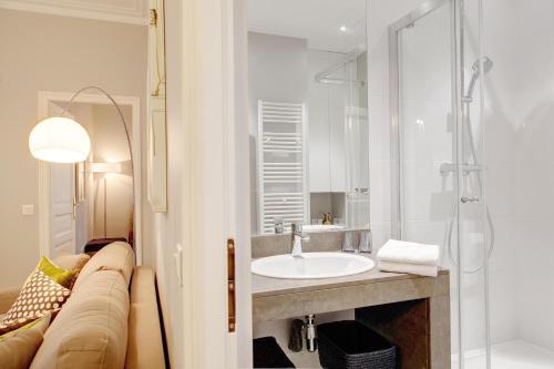 une salle de bain avec un lavabo et une douche dans l'établissement Blanc Manteau Residence, à Paris