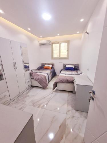 Dos camas en una habitación con paredes blancas. en New Studios for Students near MSA University, en Seis de Octubre