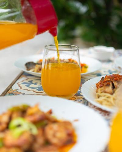 a person is pouring orange juice into a glass at Playa las Flores in Zambales