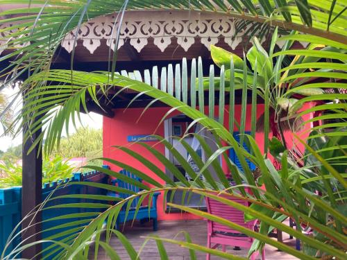 a colorful house with a plant in front of it at Piton Bungalows Ecolodges in Deshaies