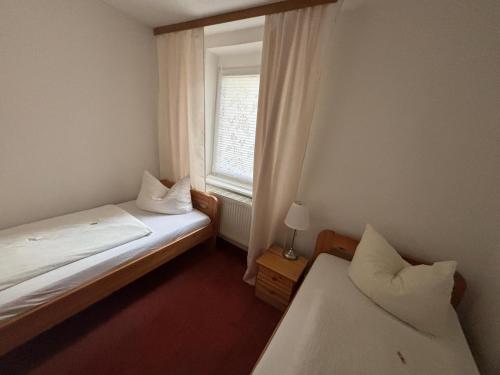 ein kleines Zimmer mit zwei Betten und einem Fenster in der Unterkunft Ferienwohnung zum Türmer in Görlitz