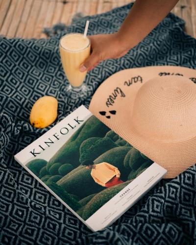 a person with a hat and a book and a drink at Playa las Flores in Zambales