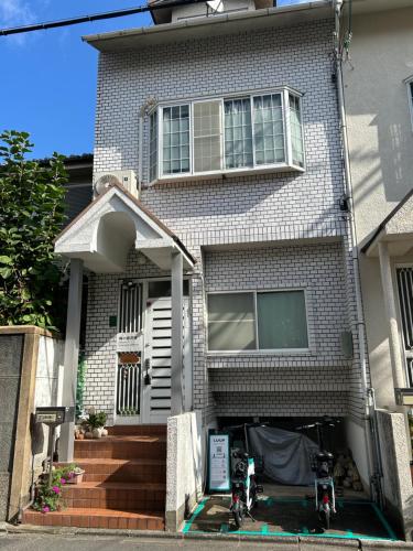 a house with two motorcycles parked in front of it at 梅小路民宿 in Kyoto