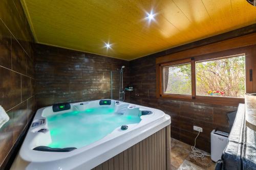 a large bath tub in a bathroom with a window at Picachico in Laroya