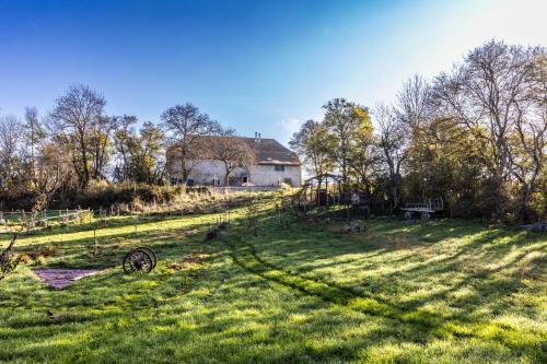 an open field with a farm house in the background at Le Galussel Gite d'étape et de séjour in Saint-Sébastien