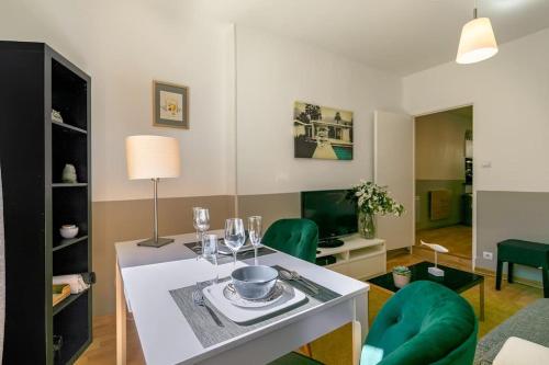- un salon avec une table et des chaises vertes dans l'établissement Le St Nicolas au coeur du centre historique, à Dijon