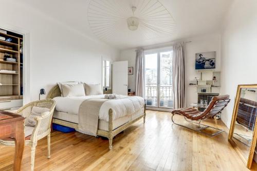 une chambre avec un lit, une table et une chaise dans l'établissement Le Bridge - Elégant & Lumineux - Neuilly, à Neuilly-sur-Seine