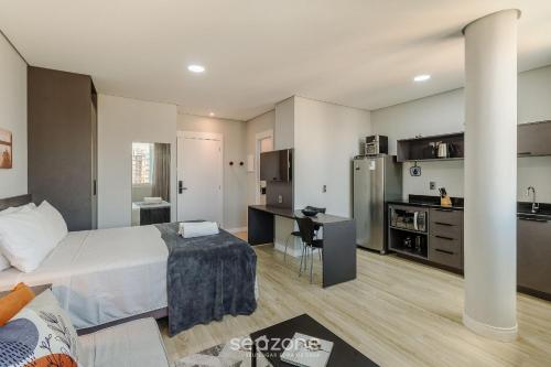 a large room with a bed and a kitchen at TCO - Apartamentos no Centro Histórico Porto Alegre/RS in Porto Alegre